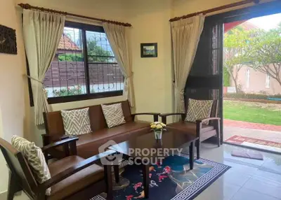 Charming living room with garden view, featuring cozy seating and elegant decor.