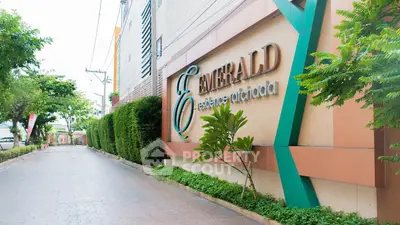 Elegant entrance of Emerald Residences with lush greenery and modern design.