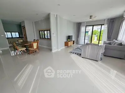 Spacious living room with modern furniture and large windows offering natural light.