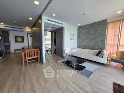 Spacious modern living room with stylish decor and open layout, featuring a cozy seating area and elegant wooden flooring.