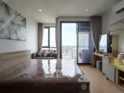 Modern bedroom with balcony and city view, featuring stylish decor and natural light.