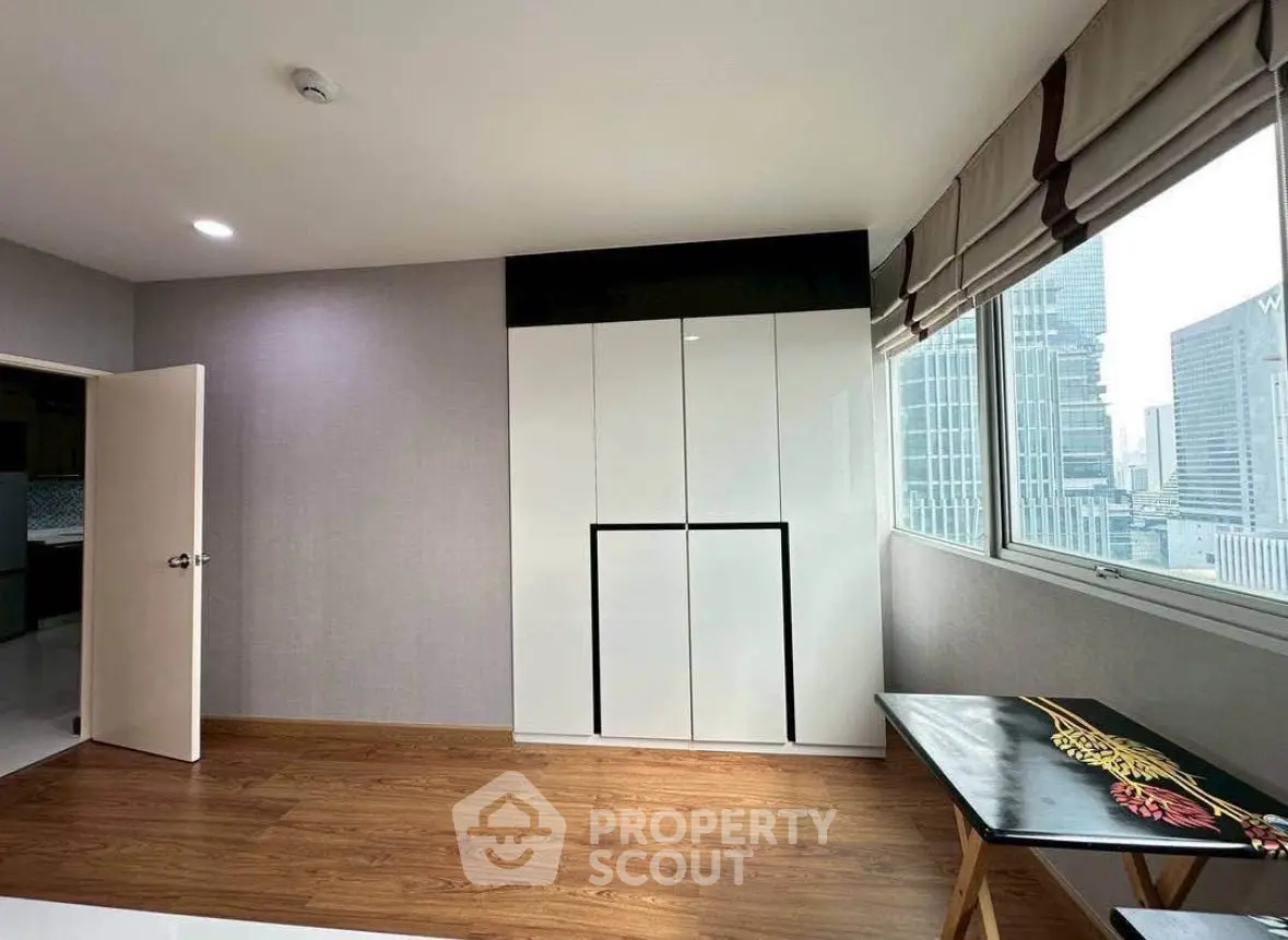 Spacious bedroom with city view and modern furnishings in urban apartment