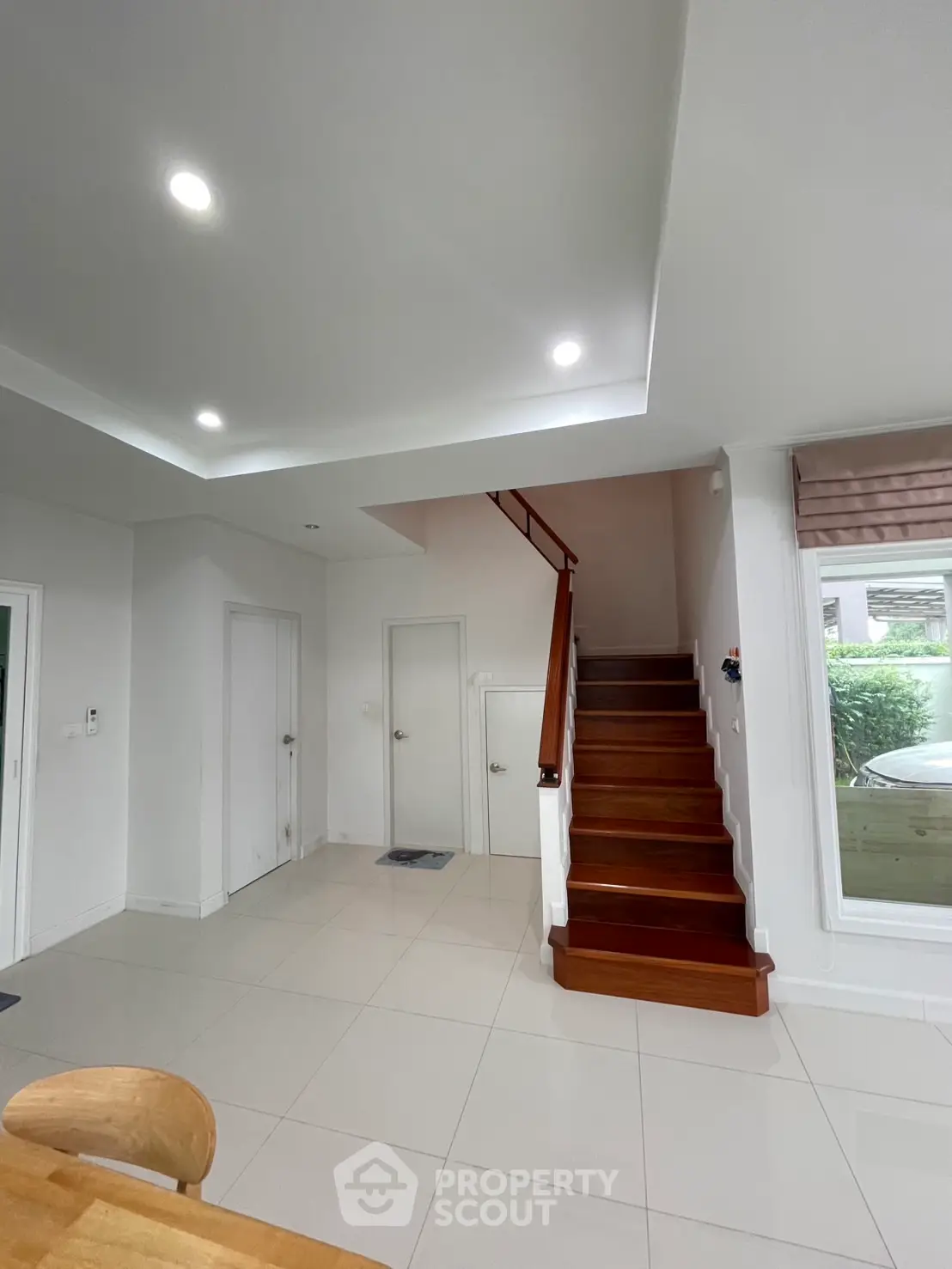 Modern interior with sleek staircase and bright lighting, showcasing contemporary design and spacious layout.
