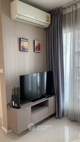 Modern living room with sleek TV setup and air conditioning, perfect for comfortable living.