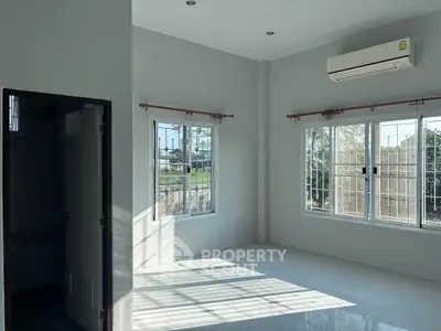 Bright and airy room with large windows and air conditioning, perfect for a cozy living space.