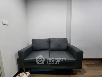 Cozy modern living room with stylish gray sofa and wooden flooring, perfect for relaxation.