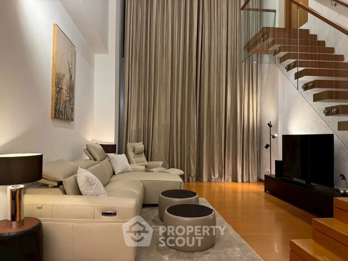 Luxurious modern living room with elegant staircase and plush seating