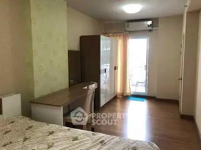 Spacious bedroom with balcony access and modern furnishings in a bright apartment.