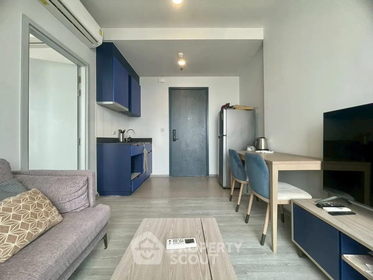 Modern living room with stylish blue kitchen cabinets and cozy seating area.