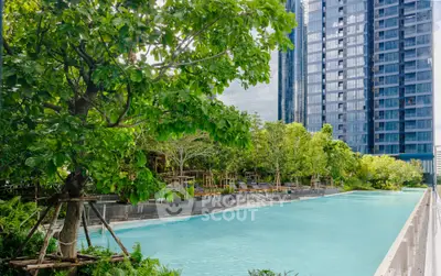 Luxurious urban poolside oasis with lush greenery and modern high-rise backdrop.