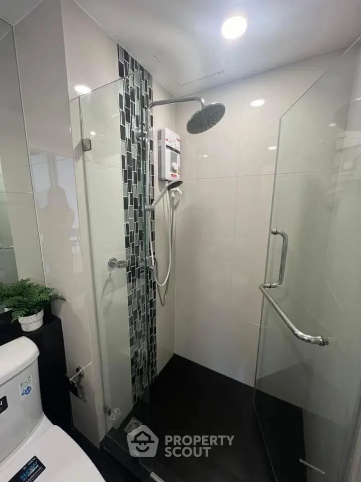 Modern bathroom with glass shower enclosure and sleek fixtures