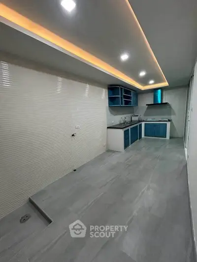 Modern kitchen with sleek design, featuring blue cabinets and recessed lighting, perfect for culinary enthusiasts.