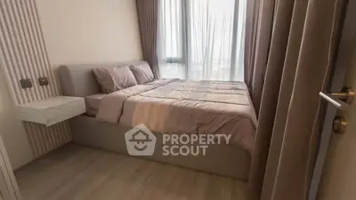 Cozy bedroom with modern decor and large window for natural light