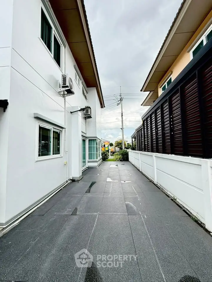 Modern exterior view of a residential building with sleek design and spacious driveway.