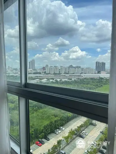 Stunning cityscape view from high-rise apartment window with lush greenery and urban skyline.