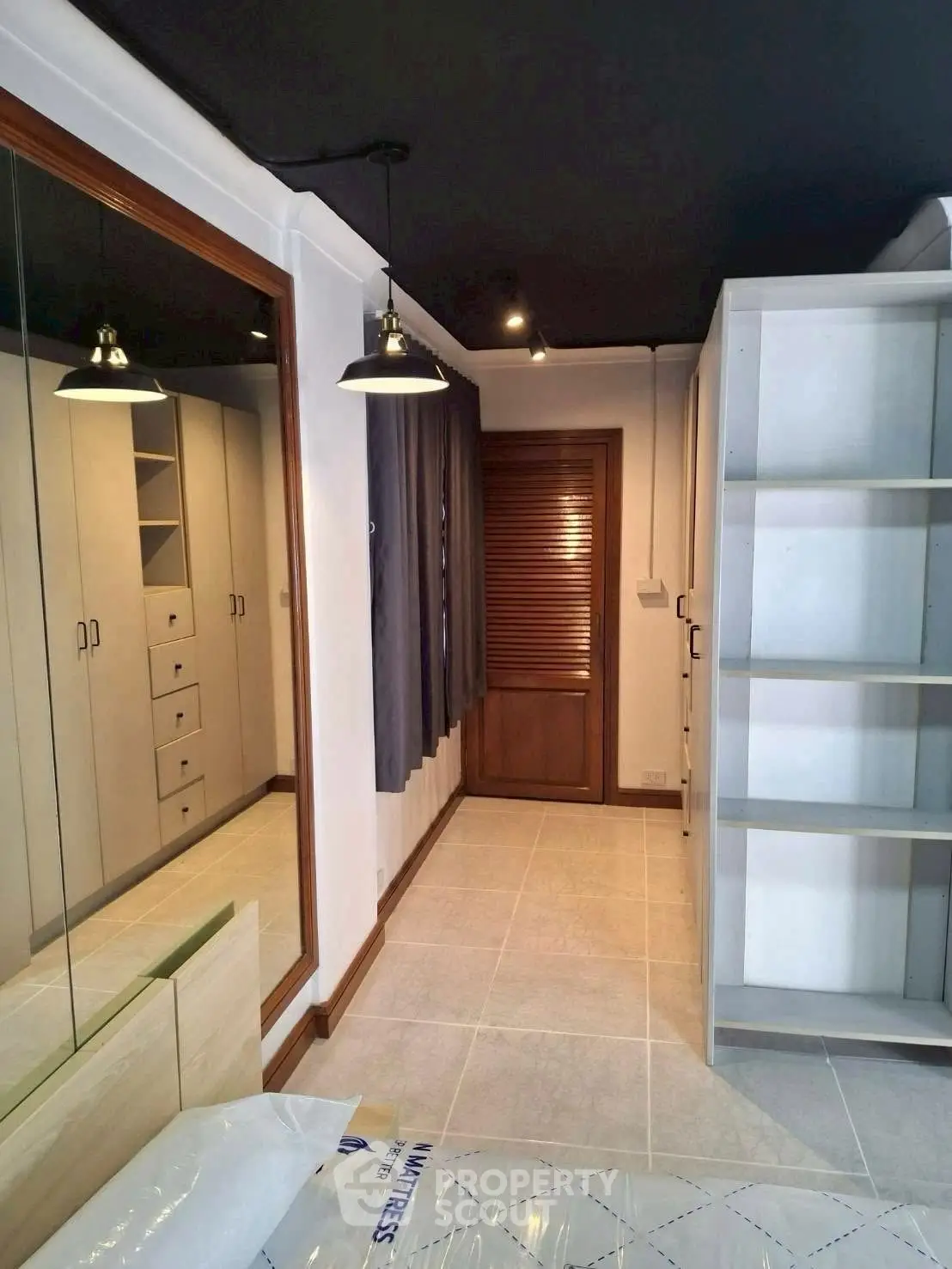 Modern bedroom with mirrored wardrobe and sleek lighting