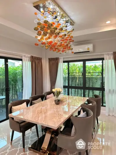 Elegant dining room with luxurious chandelier and marble table, perfect for sophisticated gatherings.