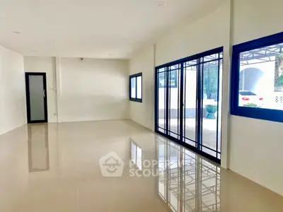 Spacious modern living room with large windows and glossy tile flooring