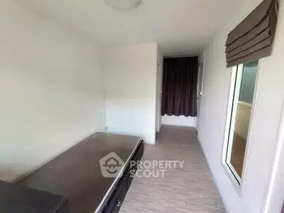 Compact bedroom with minimalist design and large window for natural light.