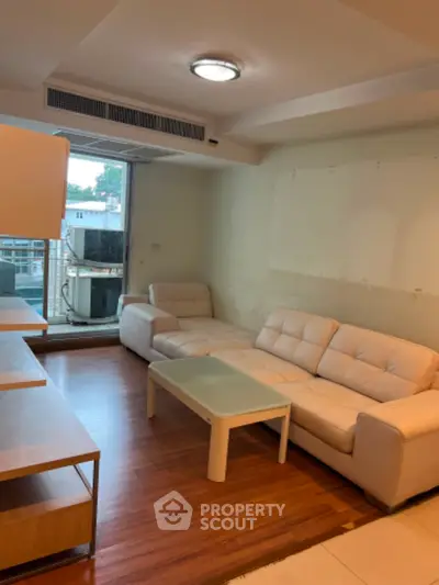 Spacious living room with modern furniture and large windows offering natural light