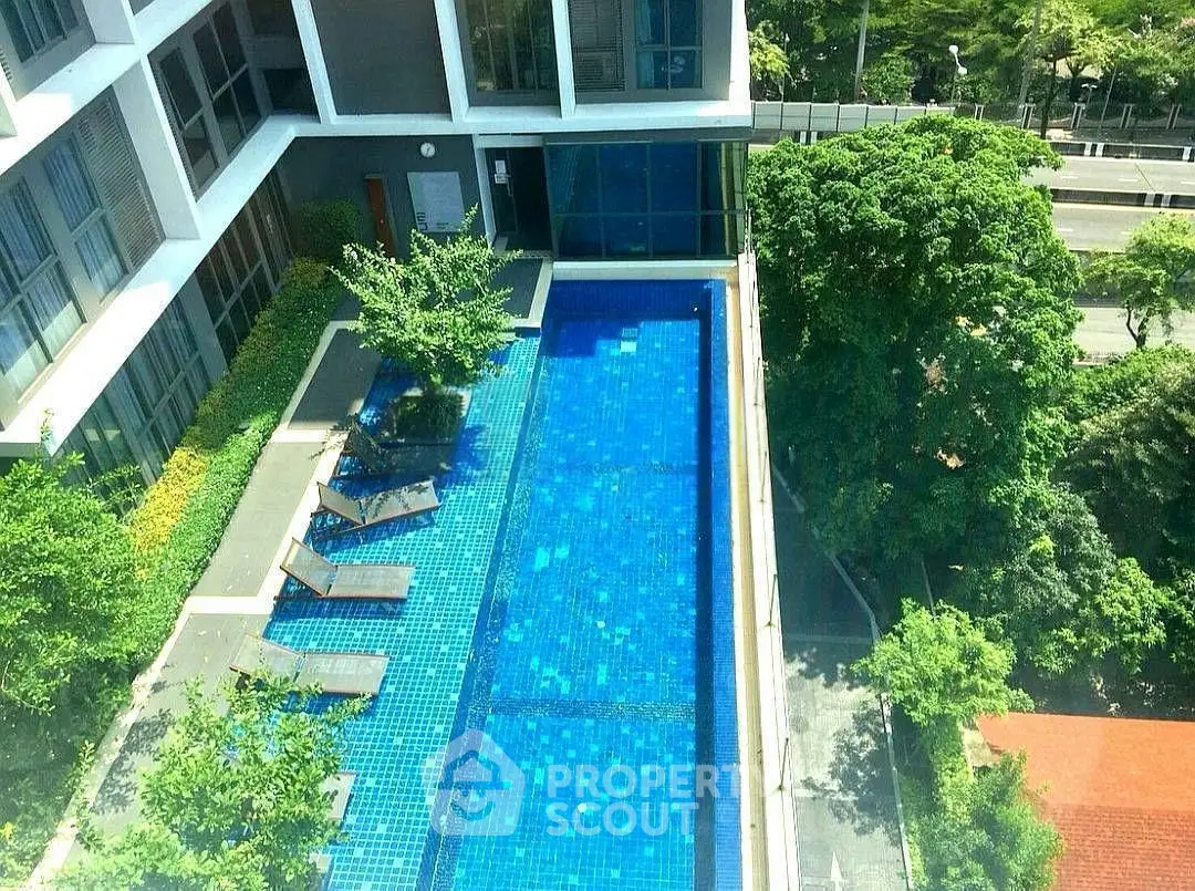 Luxurious apartment building with stunning rooftop pool and lush greenery.