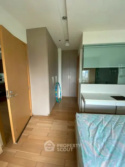Modern bedroom with wooden flooring and built-in wardrobe in a stylish apartment.
