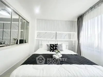 Modern bedroom with stylish decor and large window for natural light