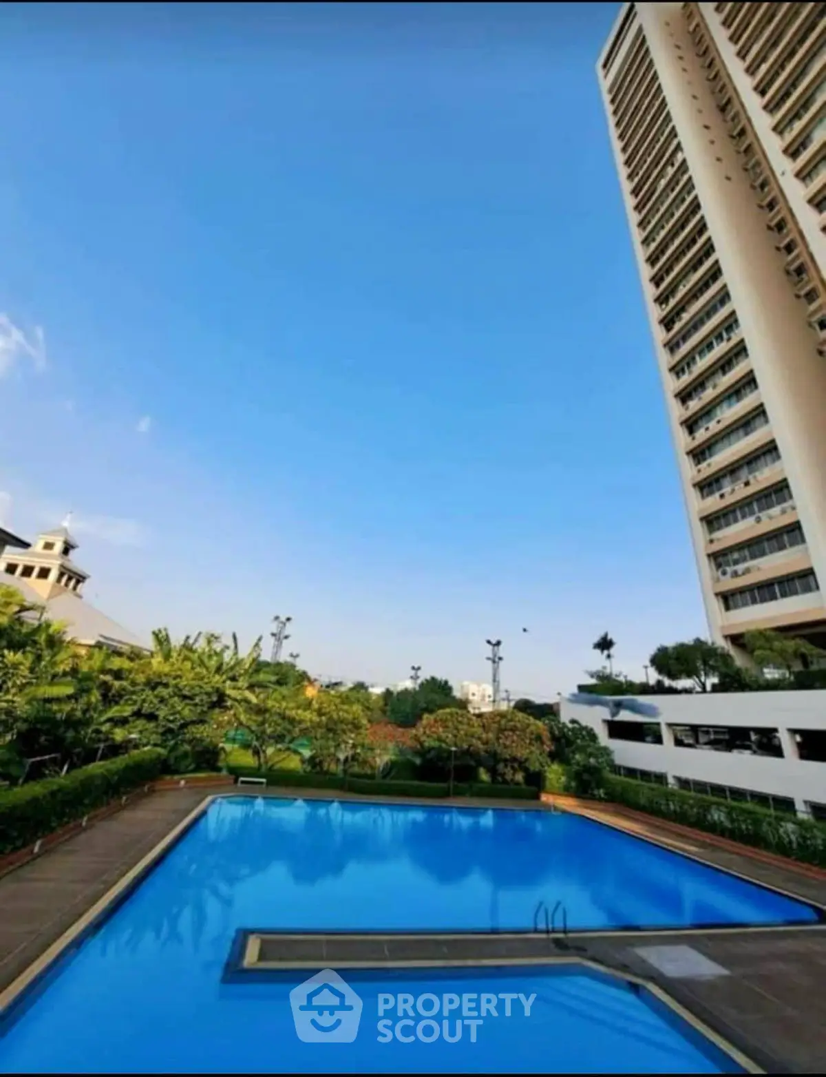Luxurious high-rise building with a stunning pool and lush greenery