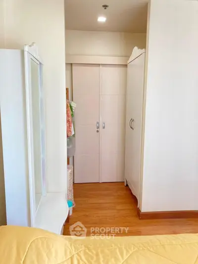 Cozy bedroom with elegant wardrobe and wooden flooring, perfect for modern living.