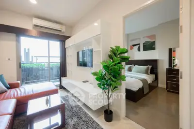 Modern living room with open layout and cozy bedroom view, featuring stylish furniture and natural light.