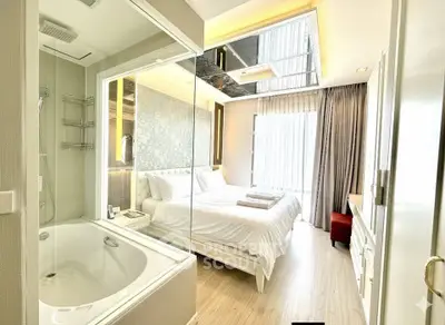 Luxurious bedroom with ensuite bathroom featuring a bathtub and elegant decor.