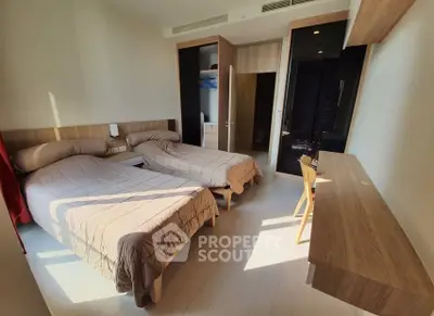 Spacious twin bedroom with modern wooden furniture and ample natural light