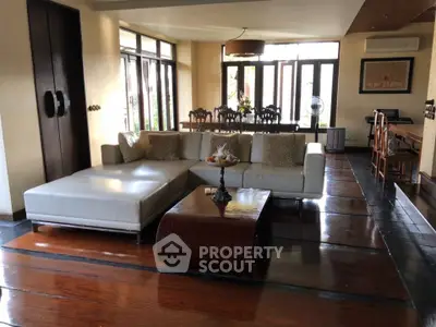 Spacious living room with elegant furniture and large windows offering natural light.