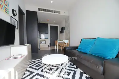 Modern living room with stylish decor and open kitchen layout in a cozy apartment.