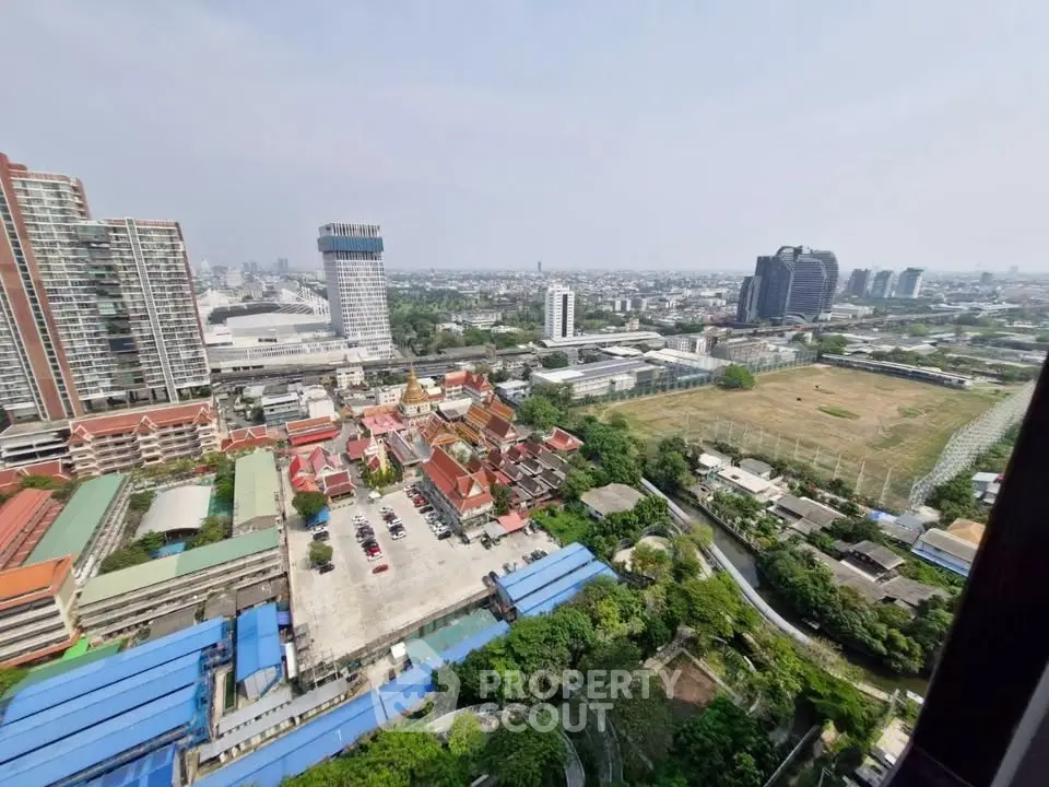 Stunning cityscape view from high-rise building showcasing urban and green landscapes.