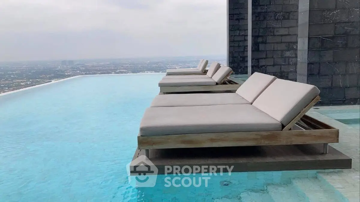 Luxurious rooftop infinity pool with stunning city views and elegant lounge chairs.
