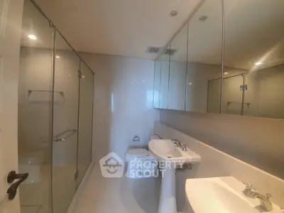 Spacious modern bathroom with glass shower and dual sinks