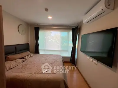 Modern bedroom with large window, air conditioning, and wall-mounted TV in a cozy apartment.