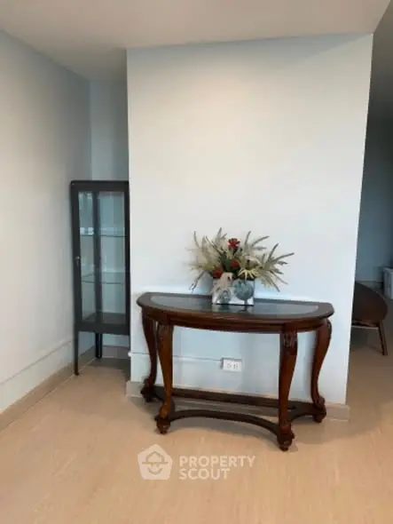 Elegant corner with wooden console table and glass cabinet in modern interior.