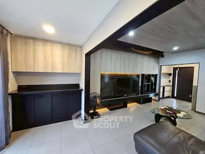 Modern living room with sleek design and built-in entertainment center.