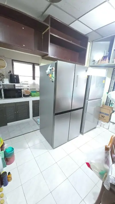 Spacious kitchen with modern double-door refrigerator and ample storage space.