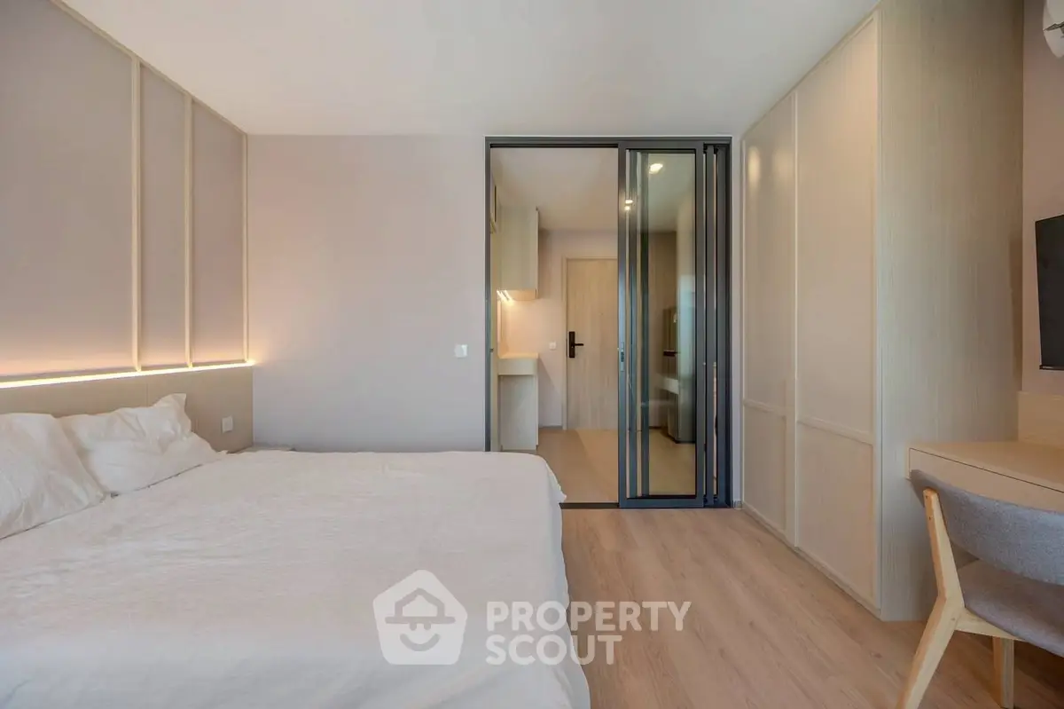 Modern bedroom with elegant design and sliding glass doors leading to ensuite bathroom.
