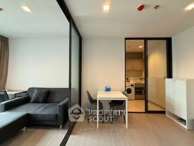 Modern open-plan living room with sleek kitchen and dining area, featuring contemporary furniture and stylish decor.
