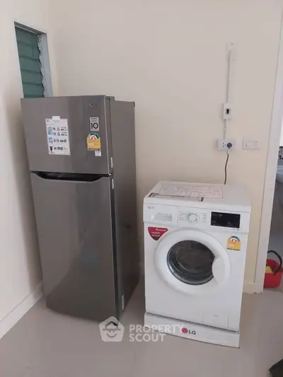 Modern kitchen with stainless steel fridge and washing machine
