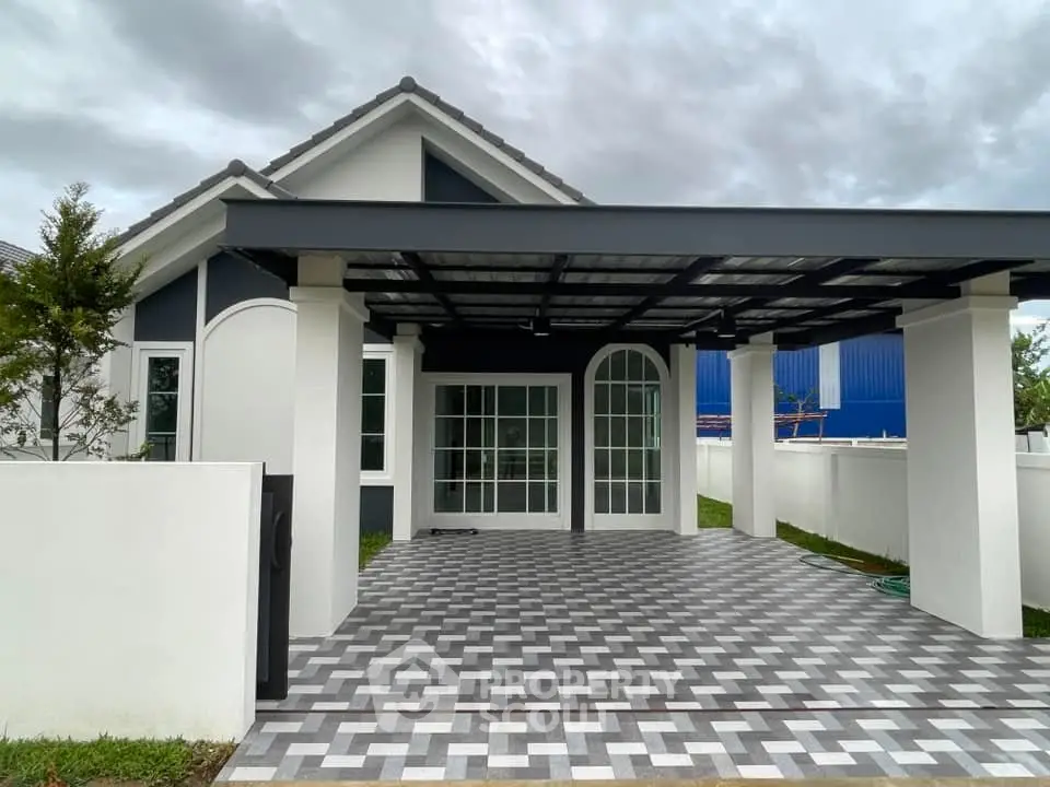 Modern single-story house with stylish carport and geometric driveway design.