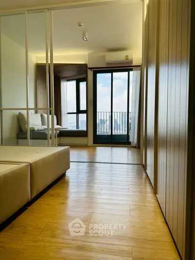 Modern apartment interior with wooden flooring and balcony view