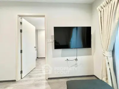 Modern living room with wall-mounted TV and elegant curtains