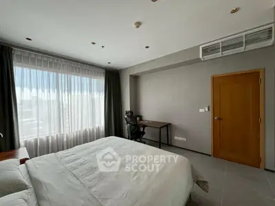 Modern bedroom with large window and study desk, perfect for comfort and productivity.