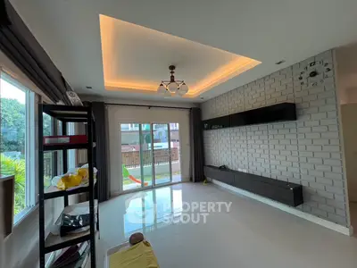 Spacious living room with modern ceiling lights and large windows overlooking garden