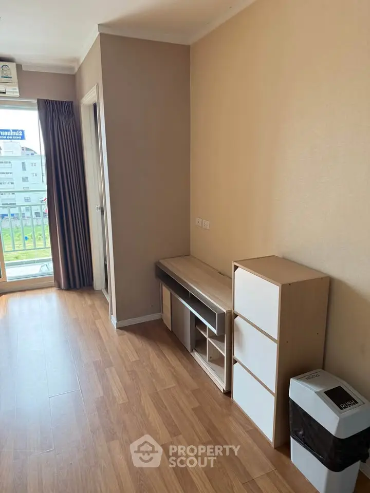 Spacious room with wooden flooring and balcony access in modern apartment